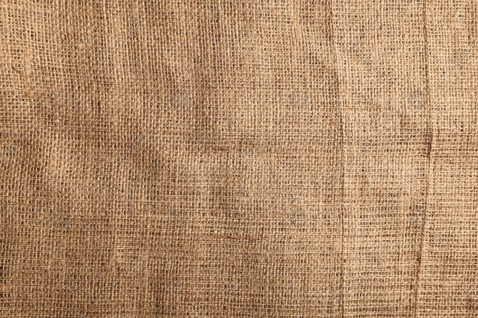 Photo of Texture of natural burlap fabric as background, top view