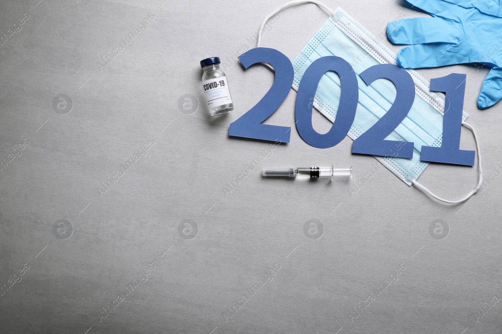 Photo of Flat lay composition with coronavirus vaccine and number 2021 on grey background. Space for text