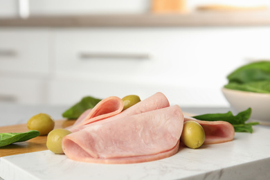 Ham with olives and spinach on table