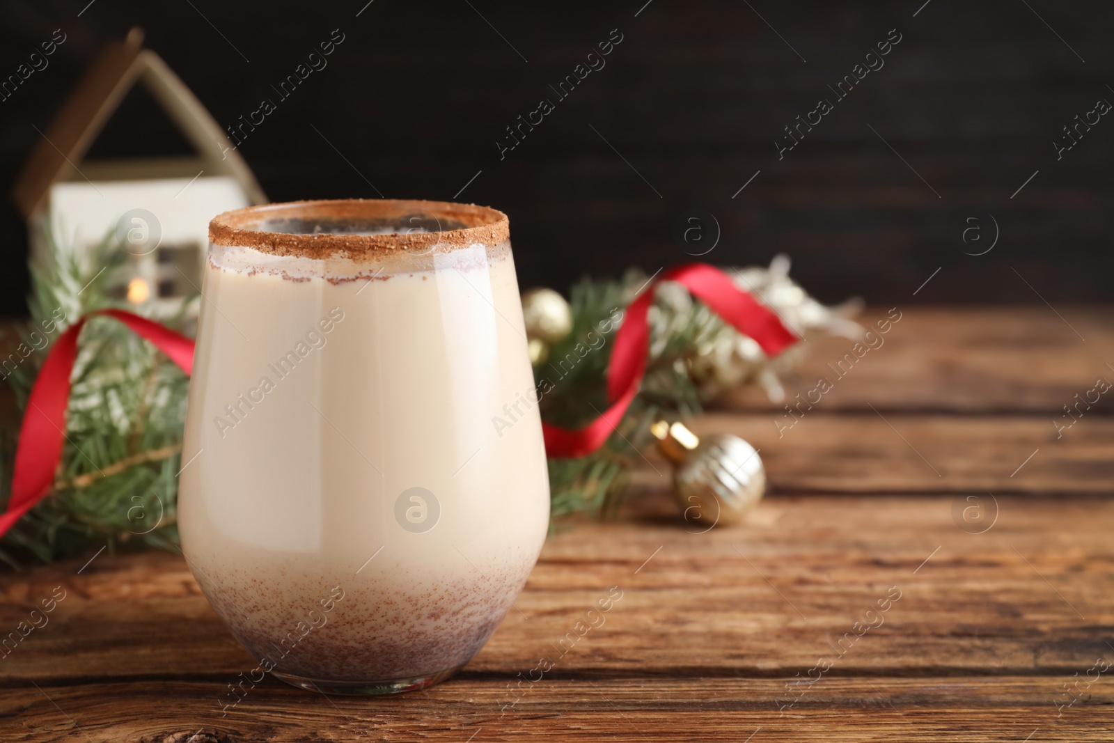 Photo of Delicious Christmas liqueur on wooden table, closeup. Space for text