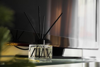 Photo of Aromatic reed air freshener on tv table indoors, space for text