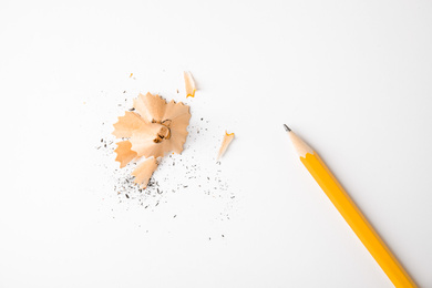 Photo of Pencil and shavings on white background, top view