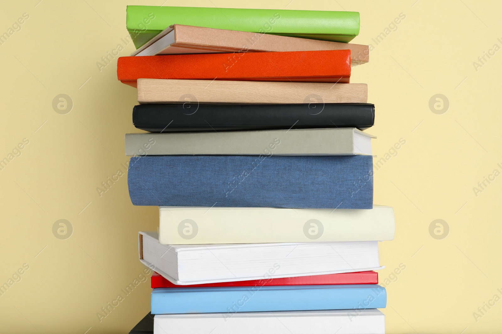 Photo of Stack of different books on beige background