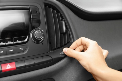 Photo of Woman adjusting air conditioner in car, closeup