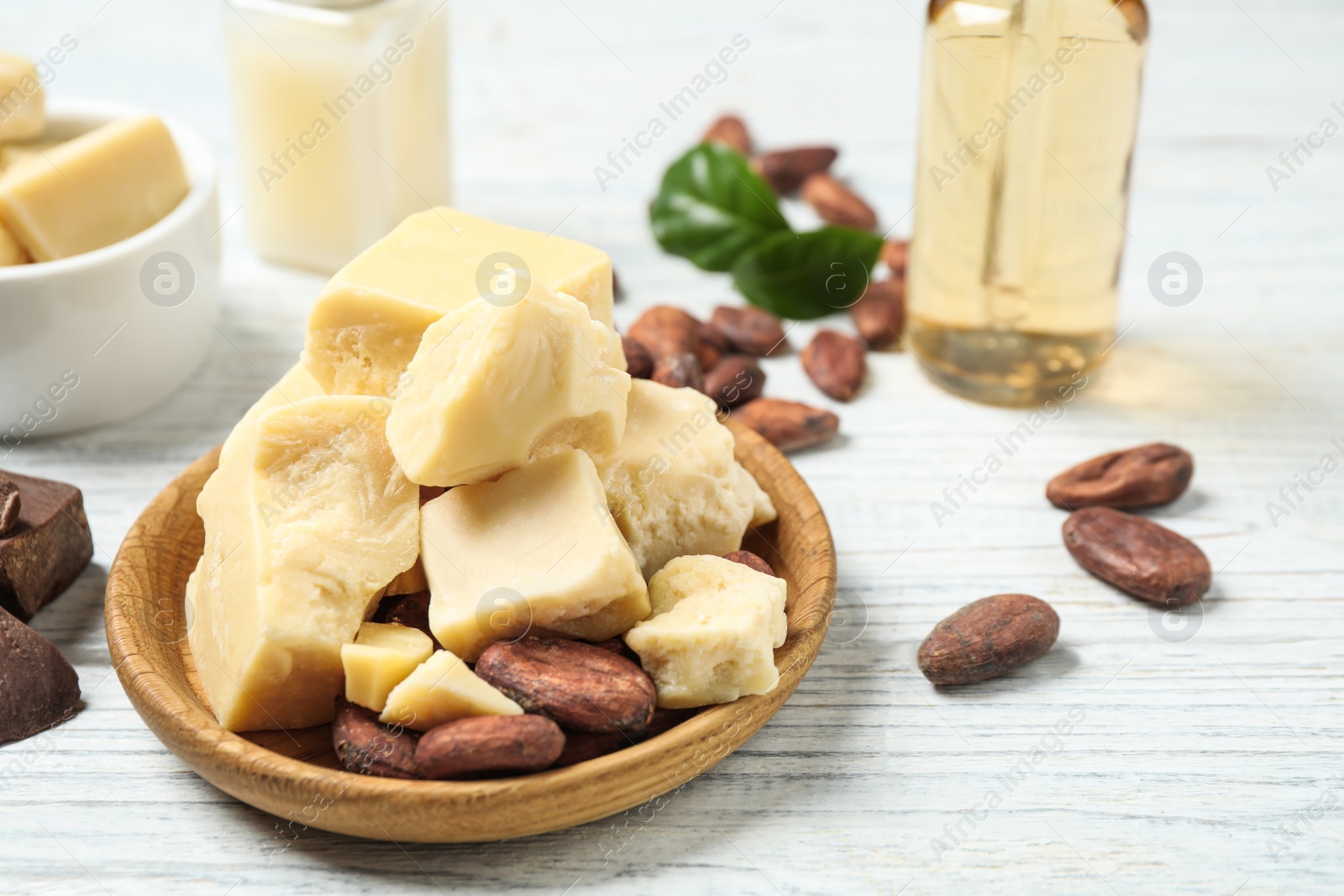 Photo of Composition with organic cocoa butter on white wooden table, closeup