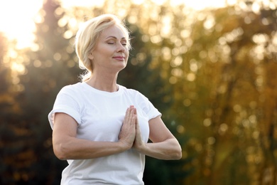 Mature woman practicing yoga outdoors in morning