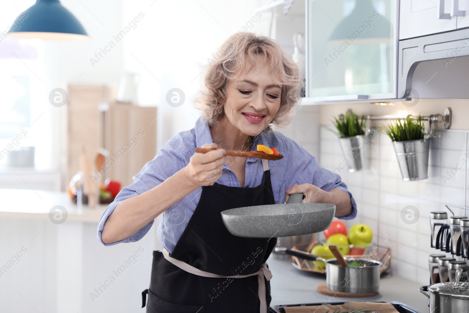 Photo of Professional female chef cooking vegetables in kitchen