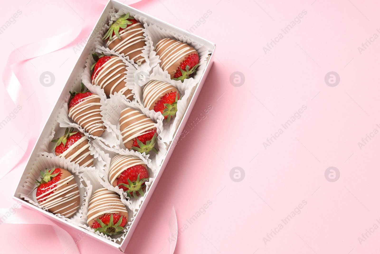 Photo of Box with delicious chocolate covered strawberries on pink background, top view. Space for text