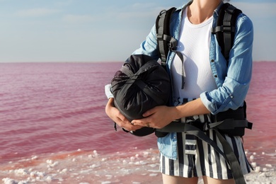 Photo of Woman with sleeping bag on coast of pink lake