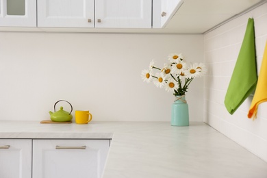 Photo of Beautiful bouquet and tea set on counter in kitchen. Interior design