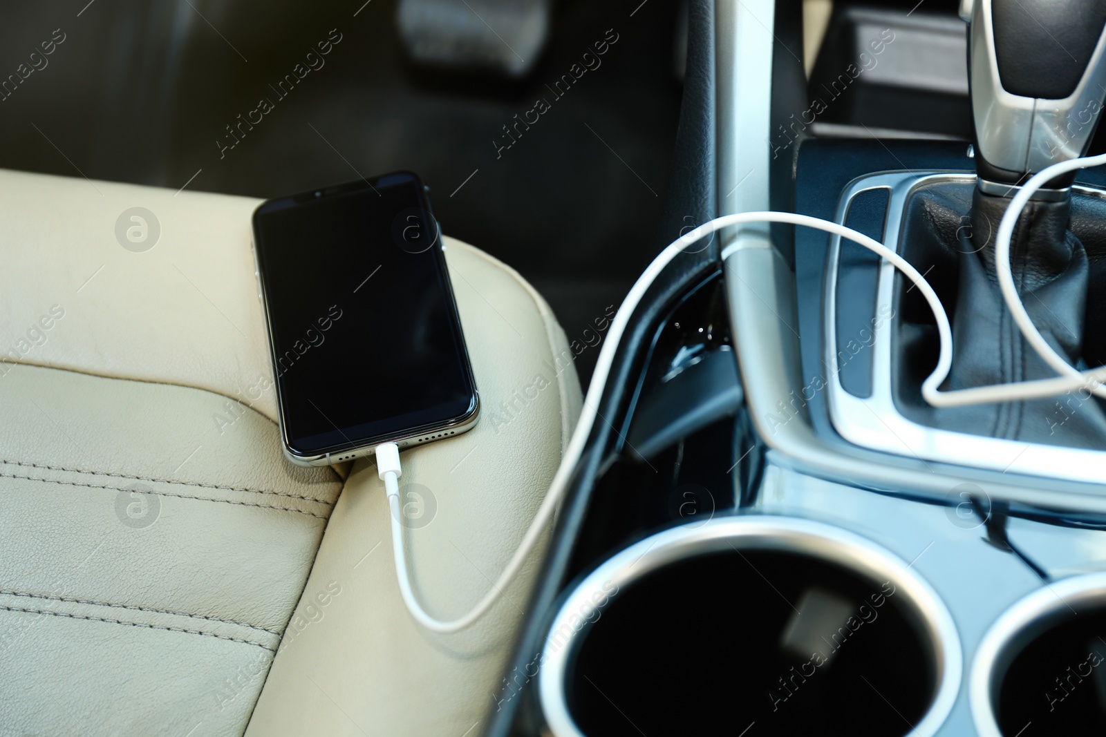 Photo of Mobile phone with charging cable in car