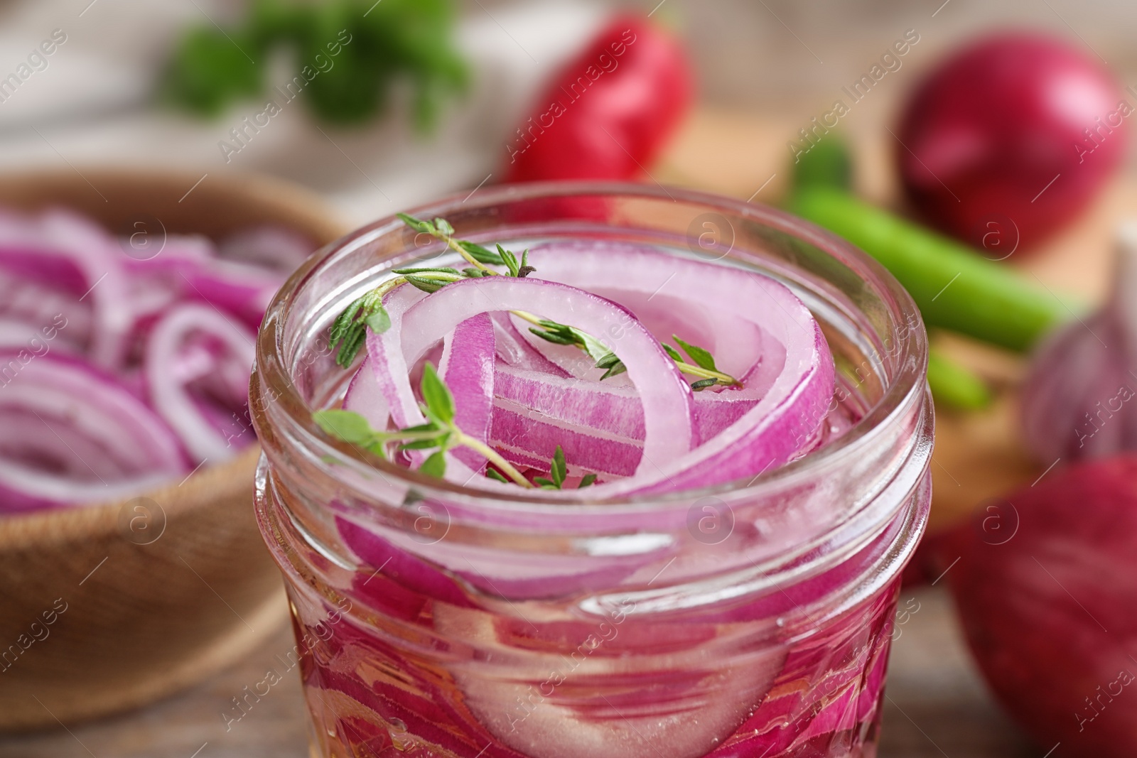 Photo of Jar of pickled onions on table, closeup