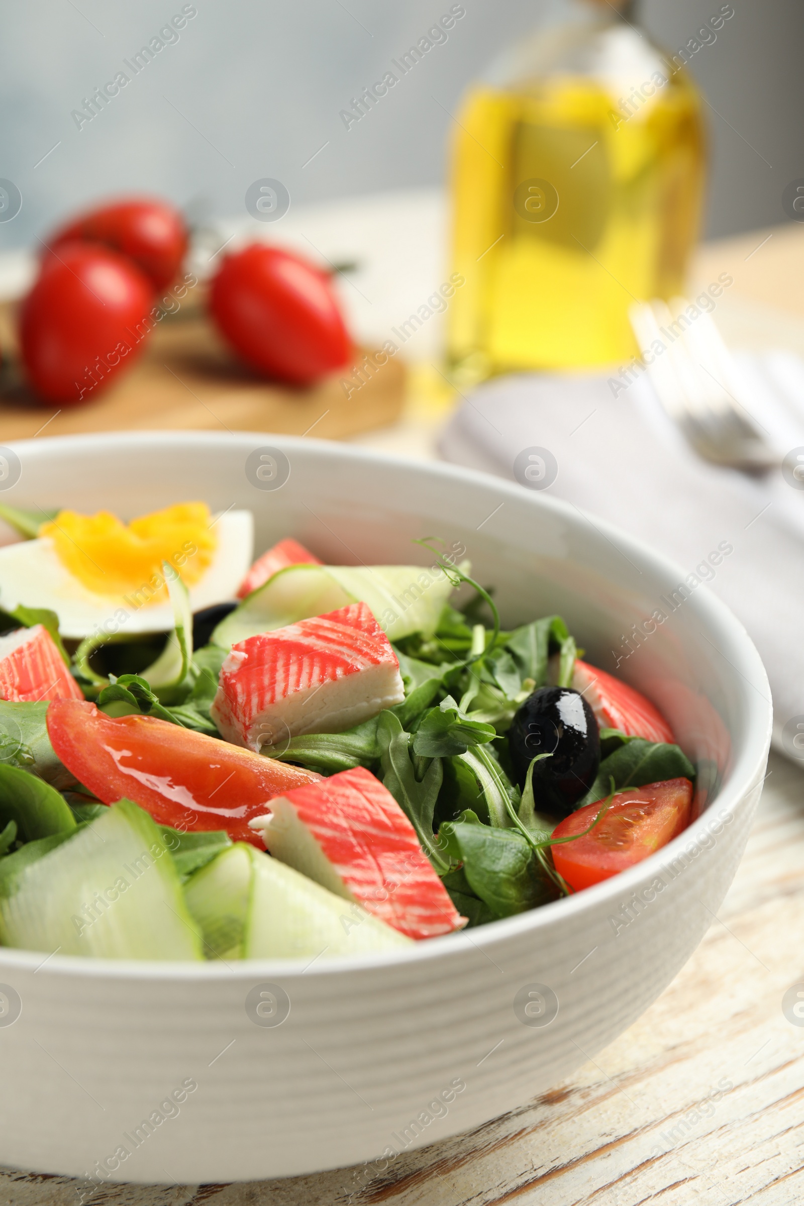 Photo of Delicious crab stick salad served on wooden table, closeup