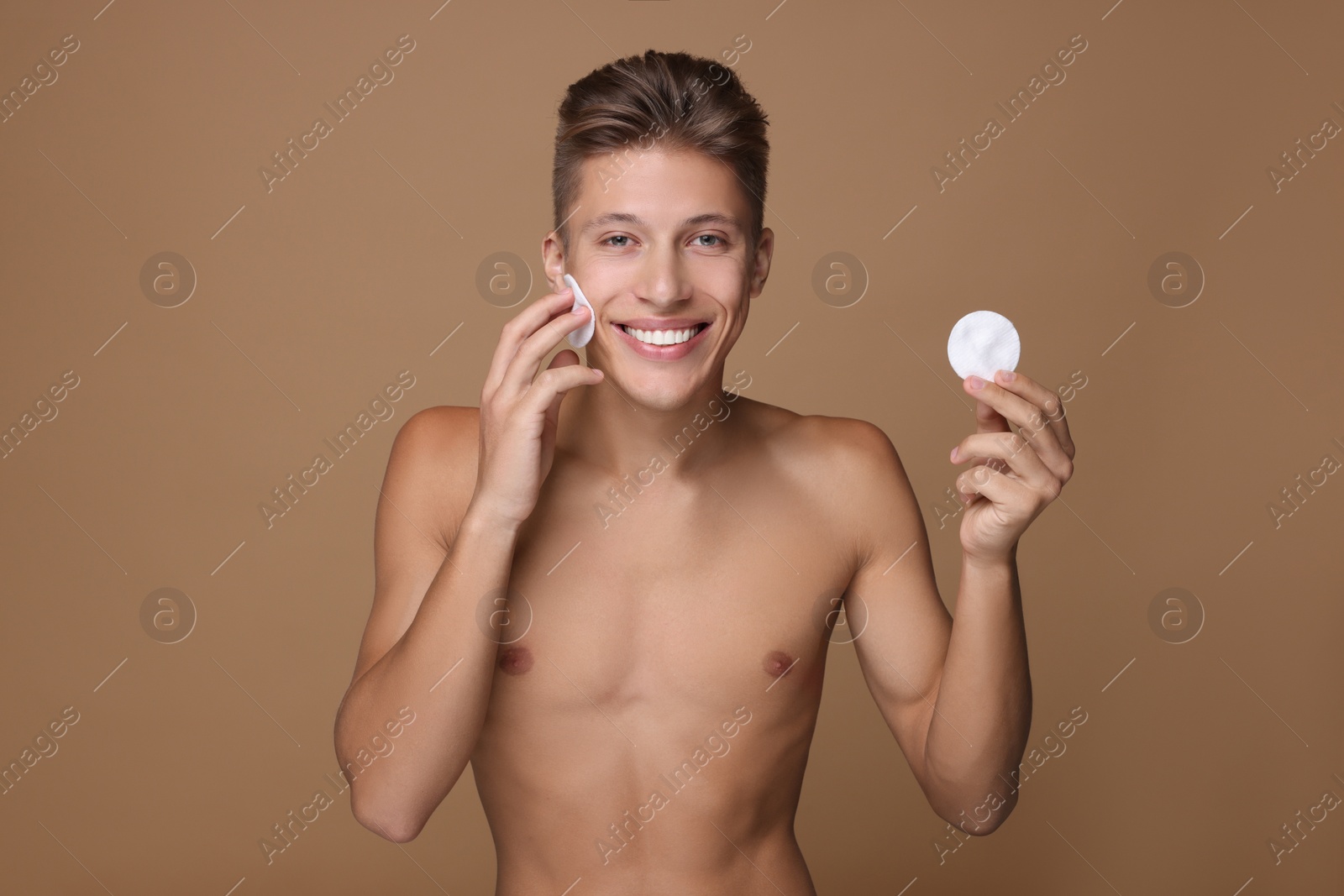 Photo of Handsome man with cotton pads on beige background