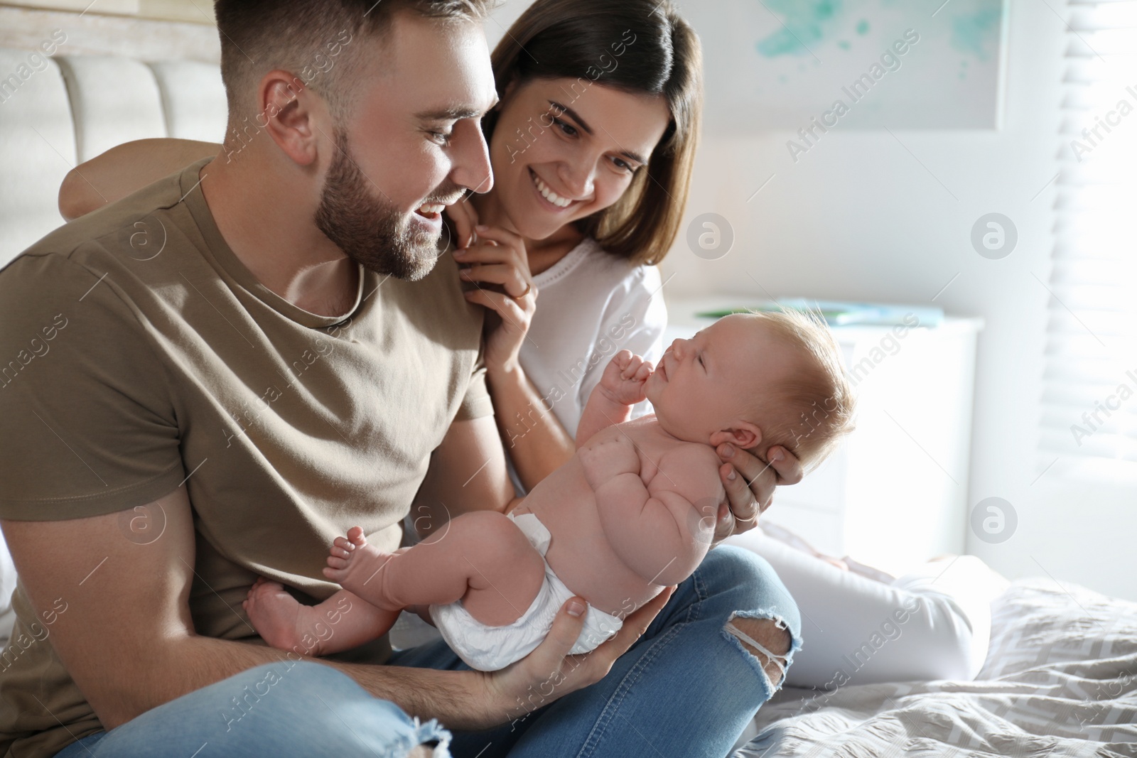 Photo of Happy couple with their newborn baby at home