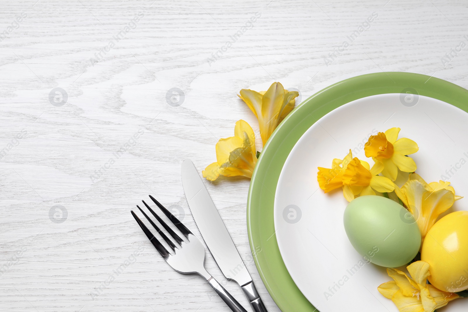 Photo of Festive Easter table setting with eggs on white wooden background, flat lay. Space for text