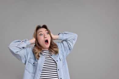 Photo of Portrait of surprised woman on grey background. Space for text