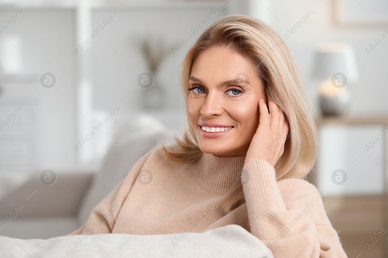 Photo of Portrait of smiling middle aged woman with blonde hair at home