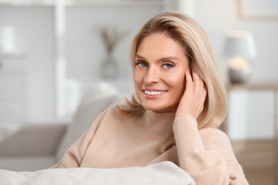 Portrait of smiling middle aged woman with blonde hair at home