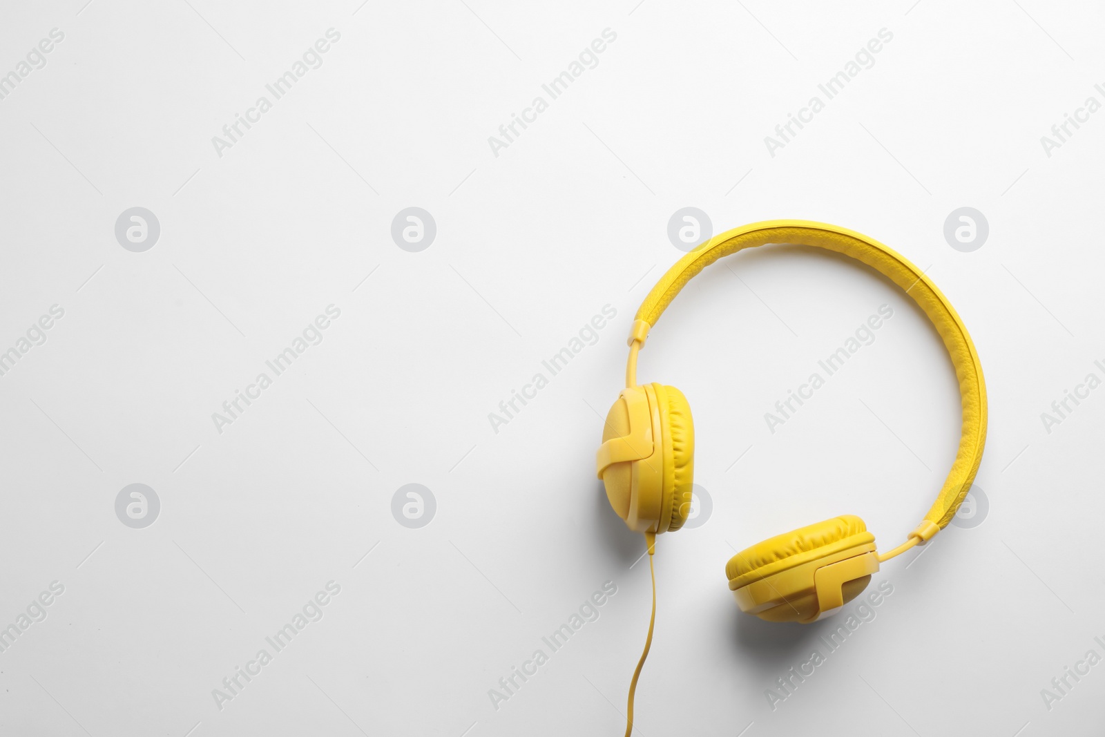 Photo of Stylish modern headphones with earmuffs on white background, top view. Space for text