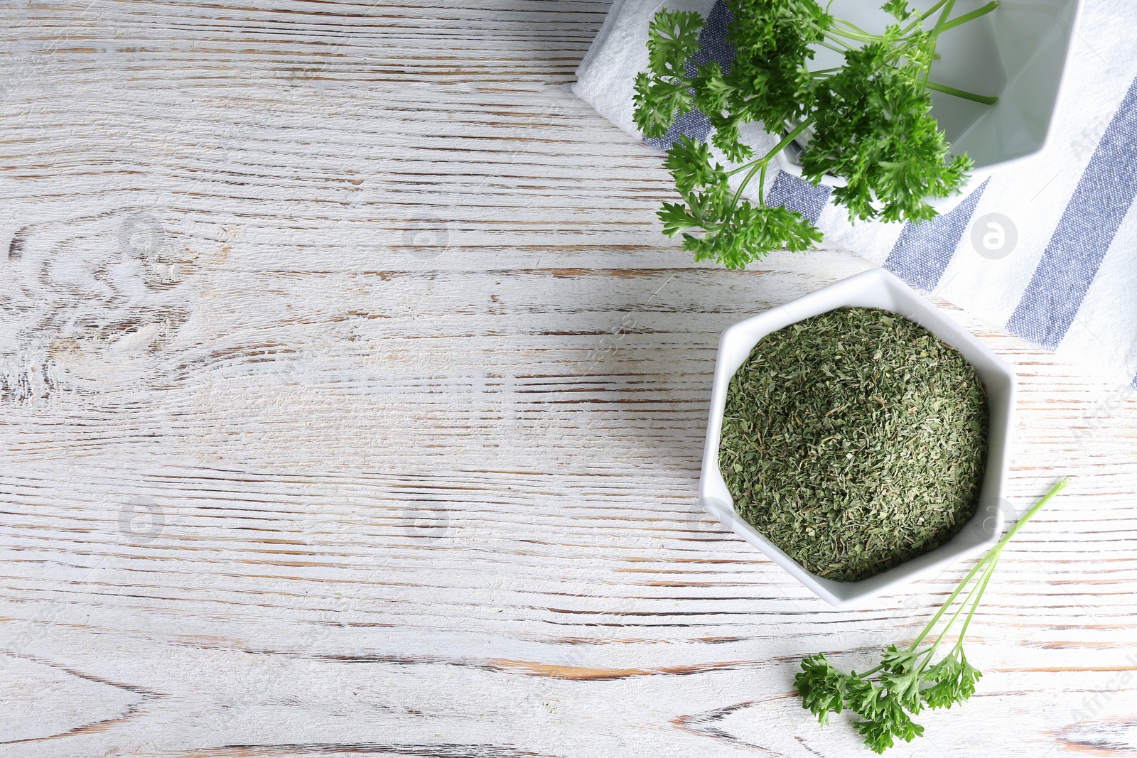 Photo of Flat lay composition with fresh and dry parsley on white wooden background. Space for text