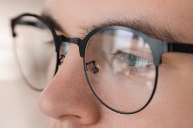 Photo of Man wearing glasses on blurred background, closeup