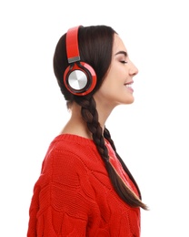 Young woman listening to music with headphones on white background