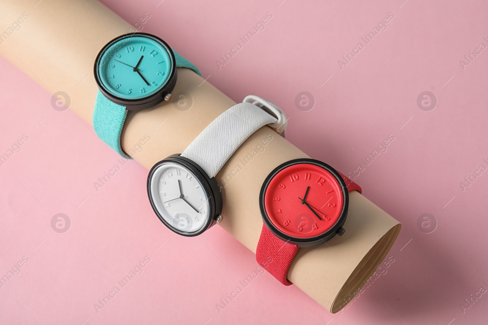 Photo of Holder with collection of stylish wrist watches on color background. Fashion accessory