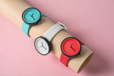 Holder with collection of stylish wrist watches on color background. Fashion accessory