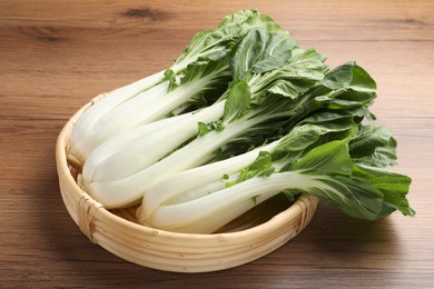 Photo of Fresh green pak choy cabbages on wooden table