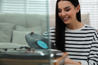 Woman listening to music with turntable at home