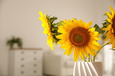 Beautiful bouquet of sunflowers in vase at home, closeup