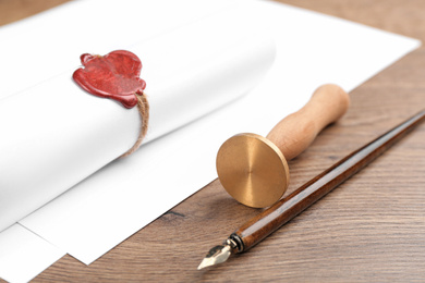 Notary's public pen and document with wax stamp on wooden table, closeup