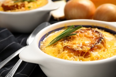 Tasty homemade french onion soup served in ceramic bowl, closeup