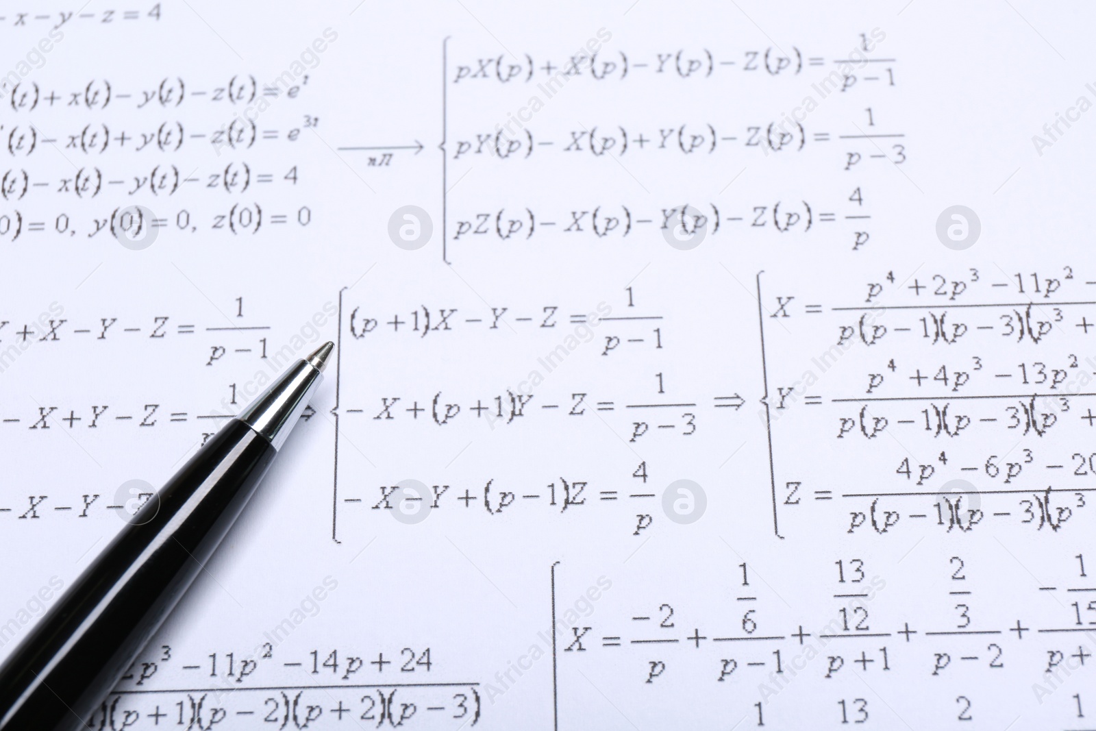 Photo of Sheet of paper with mathematical formulas and pen, closeup