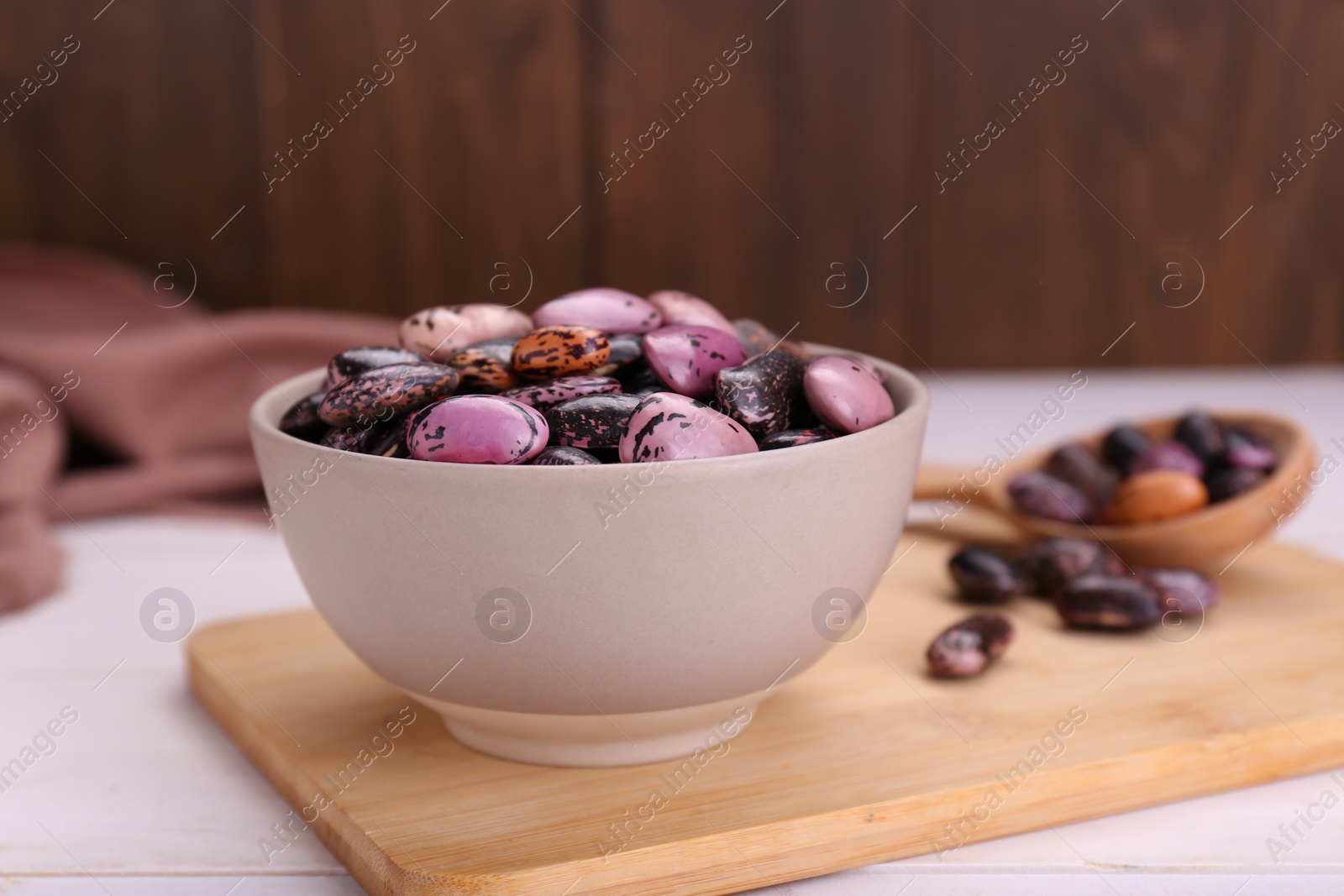 Photo of Bowl with dry kidney beans on white table