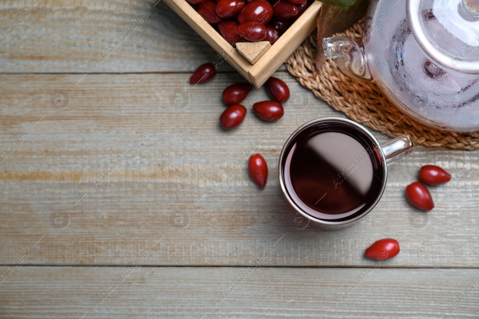 Photo of Flat lay composition with fresh dogwood tea and berries on wooden table. Space for text