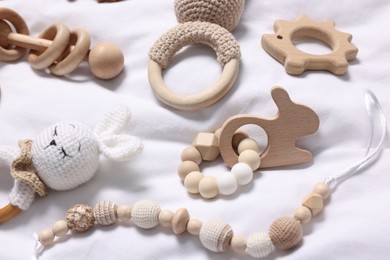 Many different baby accessories on white fabric