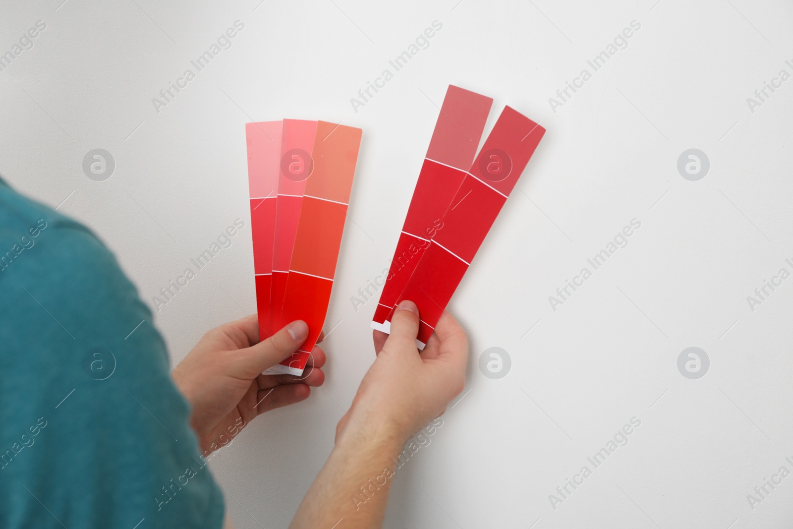 Photo of Man with palette choosing color for painting wall indoors, closeup. Interior design