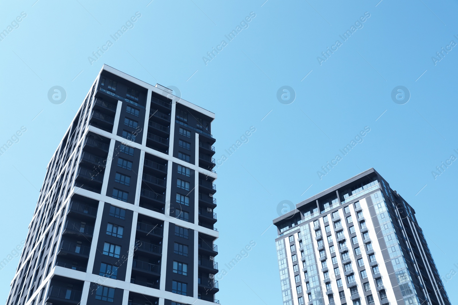 Photo of Low angle view of modern buildings against blue sky