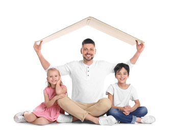 Happy father and his children sitting under cardboard roof on white background. Insurance concept
