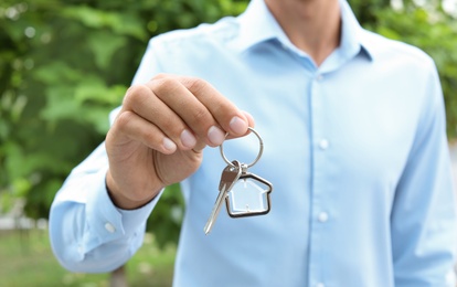 Photo of Real estate agent with key on blurred background