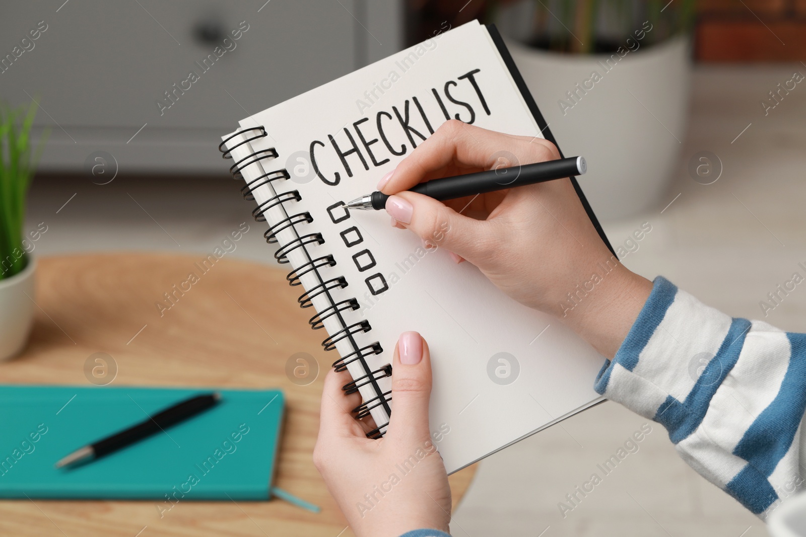 Photo of Woman filling Checklist with pen indoors, closeup