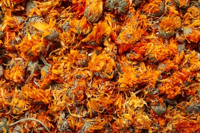 Pile of dry calendula flowers as background, top view