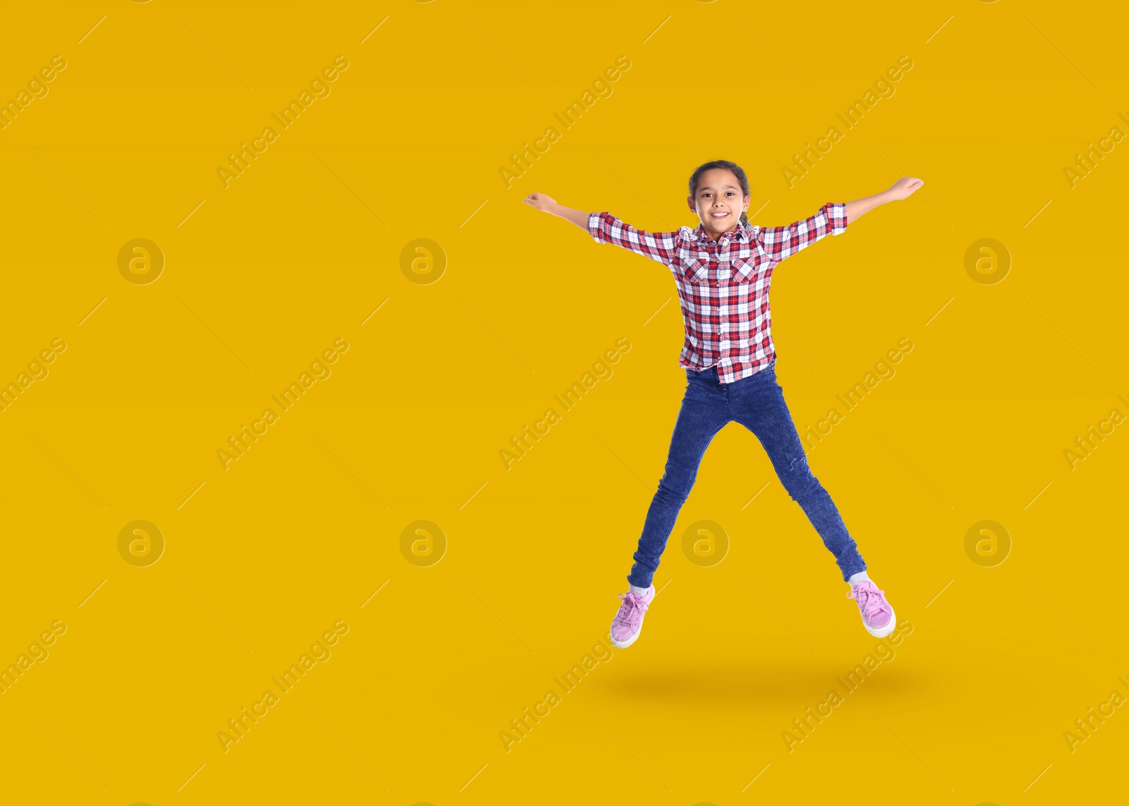 Image of Cute girl jumping on golden background, space for text