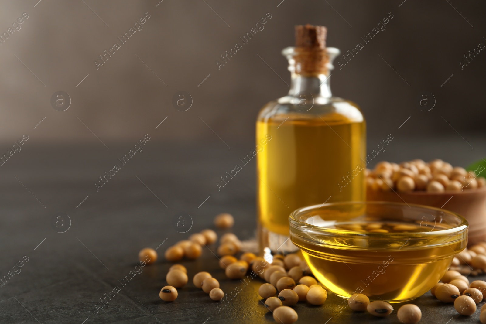 Photo of Composition with soybean oil on grey table. Space for text