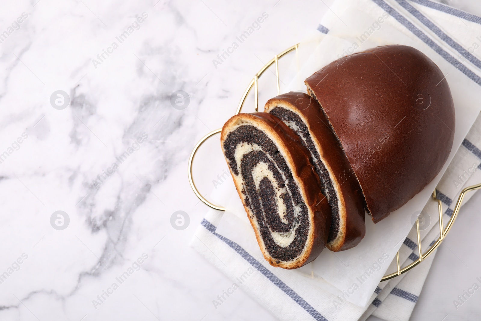 Photo of Slices of poppy seed roll on white marble table, top view with space for text. Tasty cake