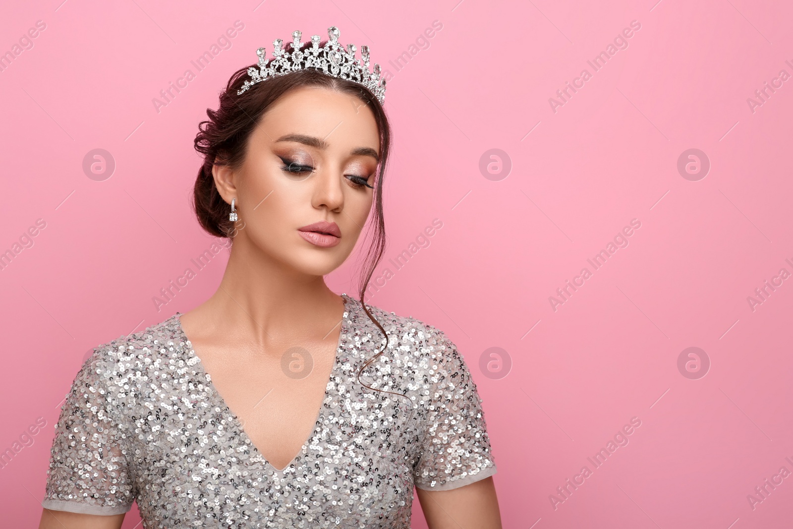 Photo of Beautiful young woman wearing luxurious tiara on pink background, space for text