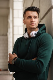 Photo of Portrait of handsome young man with headphones outdoors