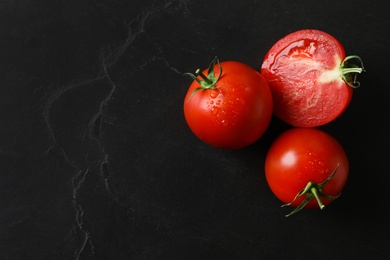 Fresh ripe tomatoes on black table, flat lay. Space for text